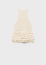 Top tejido de punto color crudo, con cuello halter y detalle de flecos en el ruedo.