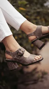 Sandalia de cuero color taupe con taco ancho y hebilla lateral redonda.