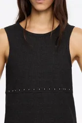 Camiseta sin mangas negra, de tejido acanalado, con escote redondo y una hilera de remaches metálicos plateados a la altura de la cintura.