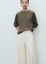 Buzo de cuello redondo y manga larga con diseño recto y holgado, confeccionado en tejido de punto suave.