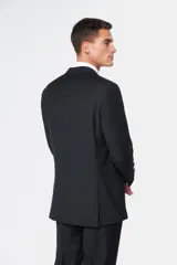 Traje clásico negro de corte fit, compuesto por saco de botonadura simple con bolsillos con solapa y pantalón de vestir a juego.