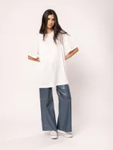 Remera blanca oversized de tela elastizada con tajos laterales y escote redondo.
