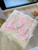 Conjunto de lencería compuesto por un bralette de encaje con broche frontal y una tanga regulable a juego. Ambas piezas están confeccionadas en encaje suave y elastizado.