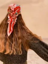 Buzo de tejido de punto con acabado brillante, confeccionado con hilado italiano. Presenta cuello redondo, mangas largas acampanadas y un corte holgado.