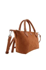 Cartera tipo bolso de mano color marrón, confeccionada en material con textura de gamuza. Presenta doble asa superior, correa larga ajustable y extraíble, y un detalle decorativo de labios en el frente junto al logo de la marca.