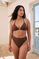 Conjunto de bikini color marrón, compuesto por un corpiño triangular con tirantes finos para atar al cuello y espalda, y una bombacha de tiro alto y corte cavado.