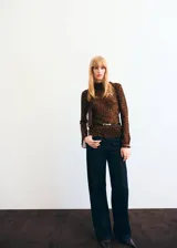 Blusa de manga larga acampanada con estampado de leopardo, cuello redondo y detalle de fular integrado en el cuello.