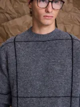 Sweater de cuello redondo confeccionado en mezcla de lana, con diseño de tejido de punto y sutiles líneas verticales en contraste.