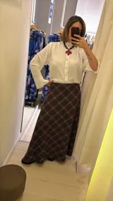 Pollera larga de corte recto con estampado de cuadros en tonos azul, gris y marrón. Presenta un diseño de tiro alto y cierre lateral.