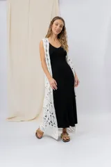 Chaleco largo tejido en punto calado color blanco, de silueta recta y caída fluida. Presenta un diseño artesanal con transparencias sutiles que aportan textura y movimiento.