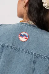 Chaleco de denim azul con bolsillos frontales aplicados y cierre con trabillas y botones frogs.