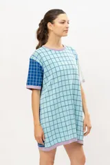 Vestido tipo remerón tejido en algodón con diseño a cuadros en tonos celeste, azul y lila.