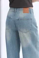 Jean wide leg de tiro medio, color celeste con lavado efecto vintage, piernas amplias y caída suelta, sin pretina y con cordón ajustable en la cintura.