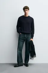 Sweater de punto en canalé color negro, de corte regular fit, cuello redondo y manga larga con terminaciones en rib.