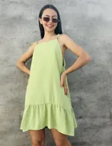 Vestido corto verde lima con textura plumeti, corte suelto, breteles finos y volado en el ruedo.