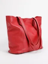 Cartera tote de cuero natural color beige, con doble asa larga para hombro y cierre superior con broche.