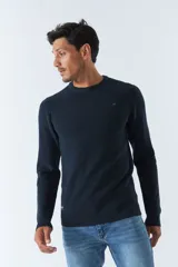 Sweater de punto color bordó, de corte clásico, cuello redondo y mangas largas. Presenta logo bordado en el pecho.