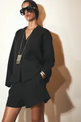 Camisa blanca de lino 100% con cuello solapa de muescas, manga larga y bajo asimétrico. Cierre frontal con botones.