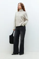 Sweater beige melange de cuello alto, tejido de punto liso y corte clásico.