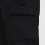 Pantalón de jogging negro con cintura elástica ajustable con cordón, bolsillos laterales y bolsillo cargo con solapa en la pierna. Logo de Nike bordado en blanco en la cadera izquierda.