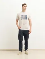 Remera color petróleo de manga corta con estampa de un edificio y texto en el frente.