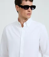 Camisa de manga larga en tejido oxford de algodón color blanco, con cuello tradicional y cierre frontal de botones.