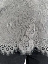 Sweater color beige con cuello alto y detalle de encaje en el frente.