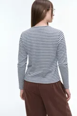 Remera de manga larga con cuello redondo, confeccionada en tejido de algodón con estampado de rayas horizontales finas en tonos gris y azul.