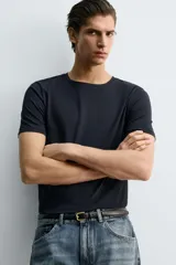 Camiseta de corte ajustado confeccionada en tejido de algodón con elasticidad, cuello redondo y manga corta.