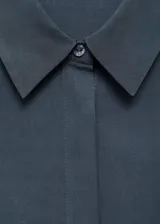 Vestido midi de diseño recto con cuello camisero y cierre frontal de botones. Presenta mangas cortas y aberturas laterales en el bajo. Incluye un cinturón ajustable con hebilla metálica.