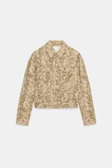 Cazadora de cuello solapa y manga larga con estampado animal print de serpiente, bolsillos con solapa en el pecho y cierre frontal con botones metálicos.