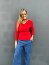 Sweater de punto acanalado color rojo, con escote en V y mangas largas con puños lisos. Diseño entallado y versátil.