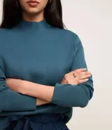 Blusa de punto de la marca Cortelle, con cuello alto y mangas largas. Confeccionada en una mezcla de viscosa y poliamida, presenta una textura suave y un diseño básico versátil.