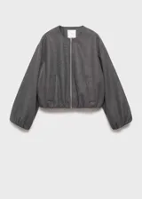 Chaqueta tipo bomber de color gris oscuro, con cuello redondo, cierre frontal de cremallera y diseño oversize. Presenta mangas largas con puños elásticos fruncidos y detalle fruncido en el bajo, además de dos bolsillos laterales.