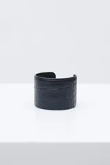 Brazalete rígido color negro con textura efecto cocodrilo.