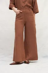 Pantalón marrón de lino, corte jeanero, con bolsillos plaque traseros y cintas laterales a contratono.