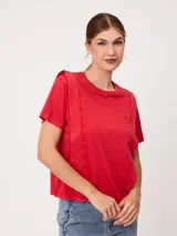 Remera de manga corta color rojo, de corte holgado, con cuello redondo y costuras decorativas frontales.