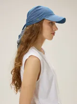 Gorro pañuelo color beige, con visera incorporada y diseño liviano con detalles deshilachados en el borde de la visera.