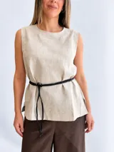 Blusa de lino color beige, sin mangas, con cuello redondo y silueta relajada. Incluye un cinturón fino desmontable de cuero negro.
