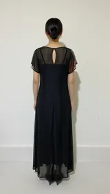 Vestido largo de tul estampado con motivos orgánicos en tonos marrones. Tiene escote redondo y corte sin mangas.