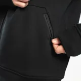 Campera Tiffosi Pocket de diseño oversize color negro, con cierre frontal completo, capucha alta ajustable con cordón y bolsillos frontales. Cuenta con puños y cintura elásticos acanalados, y un pequeño logo bordado en el pecho.