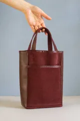 Matera tipo bolso confeccionada en cuero combinado color bordó, con bolsillo frontal exterior y compartimento interno para bombilla.