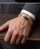 Pulsera de acero con baño de oro, compuesta por eslabones tipo reloj y una placa central con detalle de fibra de carbono.