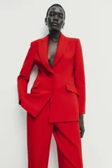 Blazer entallada de cuello solapa y manga larga con hombreras. Presenta bolsillos con solapa en el delantero, forro interior a contraste y cierre frontal con botones forrados.