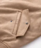 Campera bomber masculina de gamuza sintética color bordó, con cuello camisero, cierre frontal metálico, bolsillos laterales invisibles y rib elástico en puños y ruedo.
