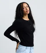 Cardigan de punto liso color negro, de corte clásico y al cuerpo, con cuello redondo, manga larga y cierre frontal con botones.