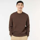 Sweater de punto color marrón, con cuello redondo y diseño liso. Presenta puños y ruedo acanalados.