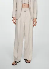 Pantalon de vestir de corte wideleg en color beige con estampado de raya diplomática. Cuenta con cintura alta, trabillas, cinturón desmontable, bolsillos laterales y bolsillos de ribete en la parte posterior.