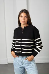 Saco de punto con cierre frontal, diseño a rayas horizontales negras sobre base color crema, de manga larga y calce holgado.