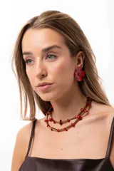 Collar de doble vuelta compuesto por bastones metálicos dorados y pequeñas piedras irregulares de color rojo. Cuenta con herrajes de acero quirúrgico y sistema de ajuste regulable.